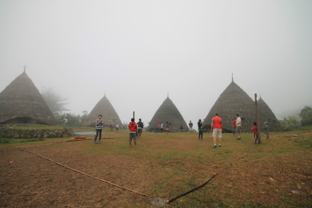 Wisatawan dan Warga Bermain Volly di Lapangan Desa Waerebo
