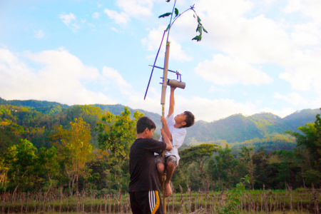 Kegembiraan anak desa memasang kincir angin di sawah