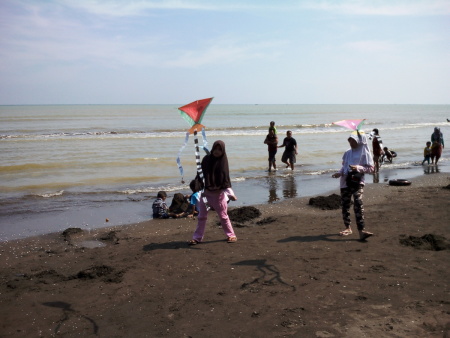 Bermain layangan di pantai