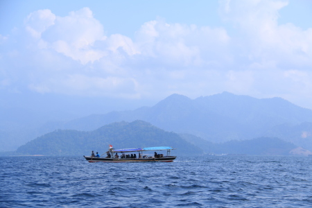 Menyebrang laut berlatar perbukitan