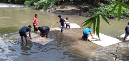 Kebersamaan mencuci tikar masjid di sungai