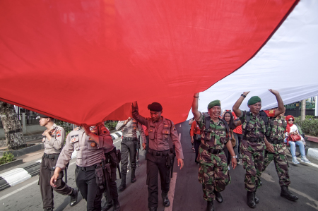 TNI dan POLRI bersatu membentangkan bendera merah putih
