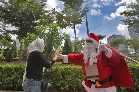 Pegawai dari Cocop.id berkostum Santa Claus membagikan kopi grat