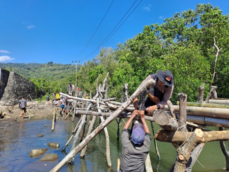 Warga Desa bergotong royong membangun jembatan bambu untuk penyeberangan