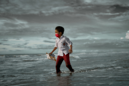 Anak sekolah dasar bermain air di pantai